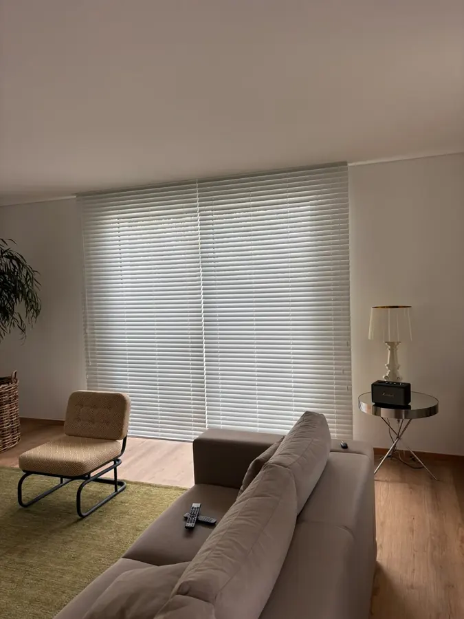 Estores laminados de madeira brancos numa sala de estar