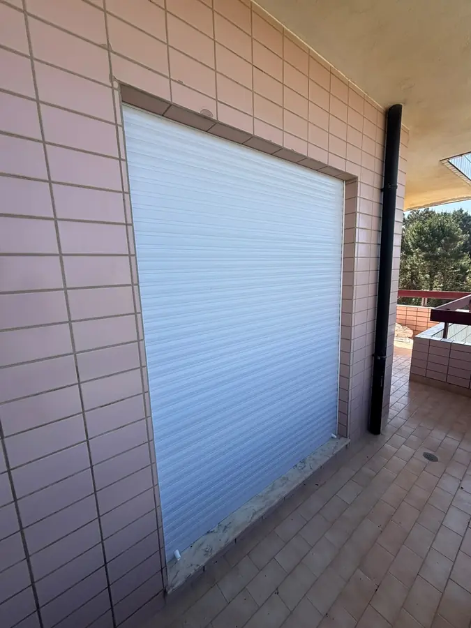 Persiana em PVC branca fechada numa varanda de azulejo