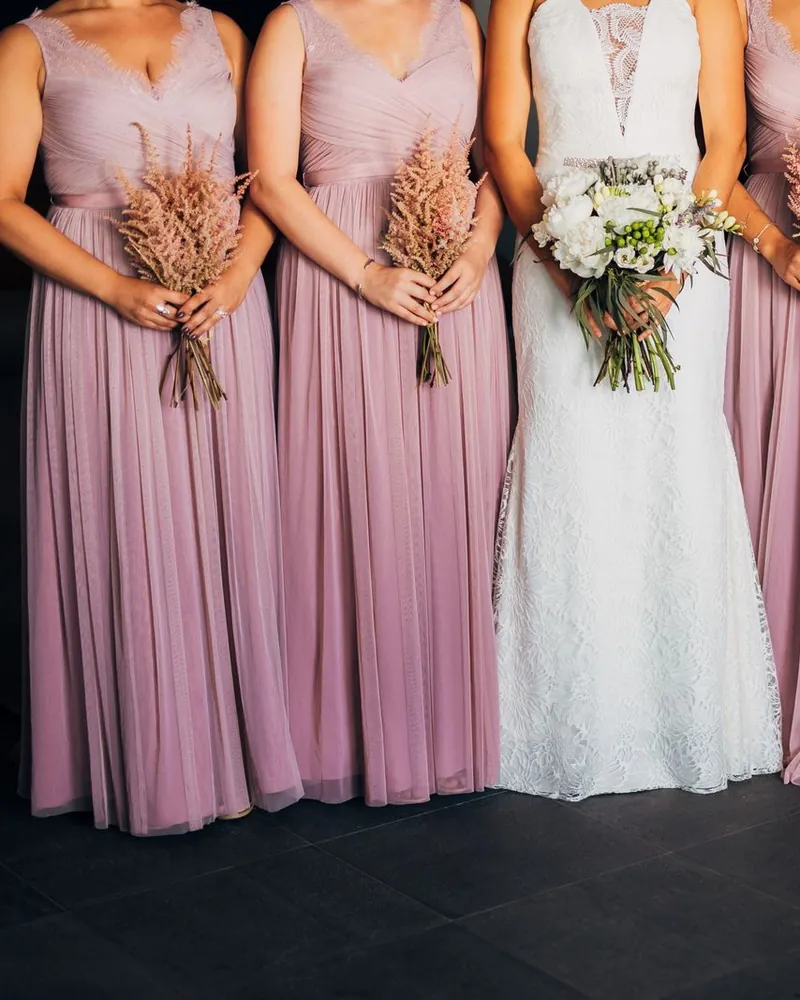 Modelo ALMA: damas de honor com vestidos compridos em rosa velho, ao lado da noiva.