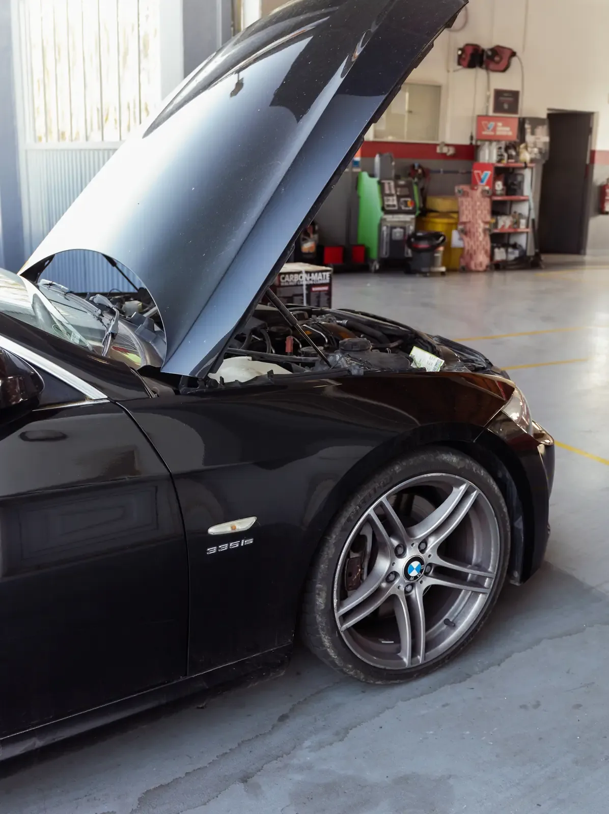 BMW 335is preto de capô aberto na oficina