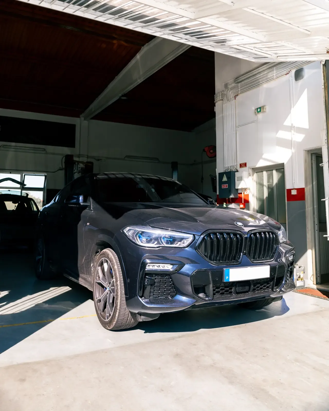 BMW X6 azul-escuro dentro da oficina